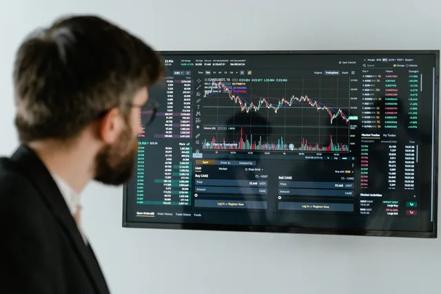 A businessman in a suit looks at a screen displaying stock market charts and data analysis. What an advert for productivity software must be able to prove