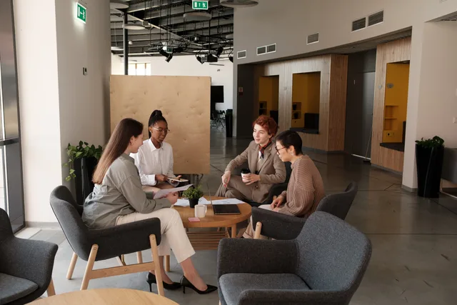 Group of professionals collaborating in a modern office lounge area, engaging in team discussions. Audience research for productivity software, from recruitment frame to interviews without selling