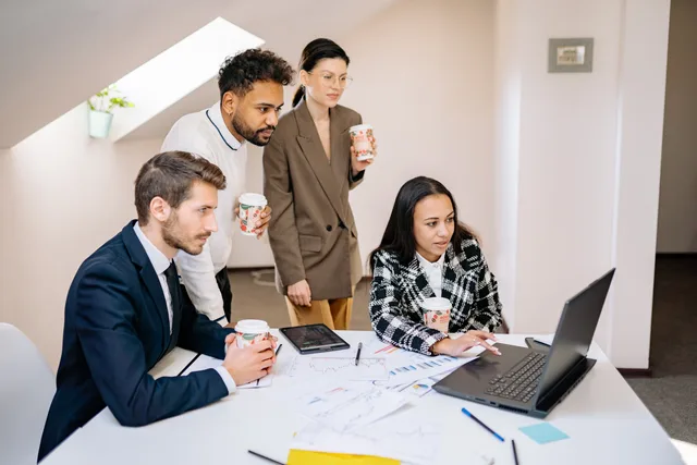 A diverse team collaborates in a modern office, using laptops and tablets for planning and brainstorming. How to ask five productivity software providers for comparable quotes