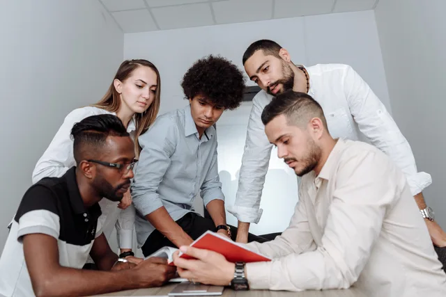 A multicultural team engaged in a collaborative office meeting, discussing ideas around a table. Turning a broad business count into an auditable productivity software market range