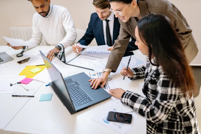 Diverse team working together on a project in a modern office environment. Running productivity software as a dependable service with an operating charter