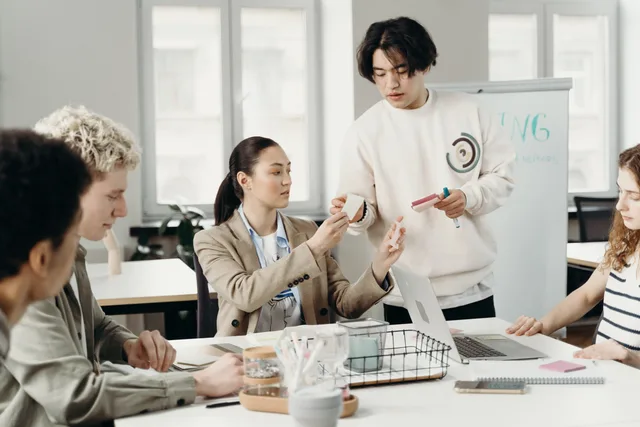 A diverse group of young adults collaborating in a modern office setting, discussing a project. A quality checklist for a productivity workflow before launch and after every material change
