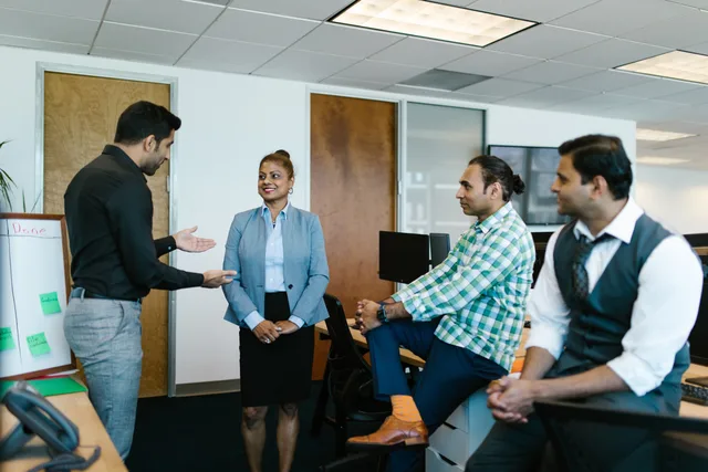 A diverse group of colleagues engaged in a collaborative meeting in a modern office setting. Name the work before the software when choosing productivity tools and suppliers